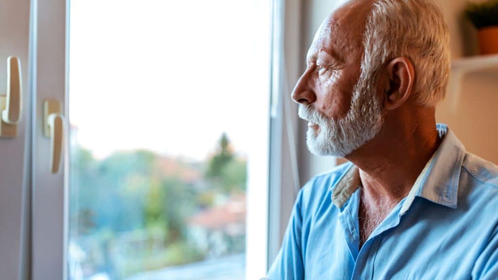 An old man looking outside the window