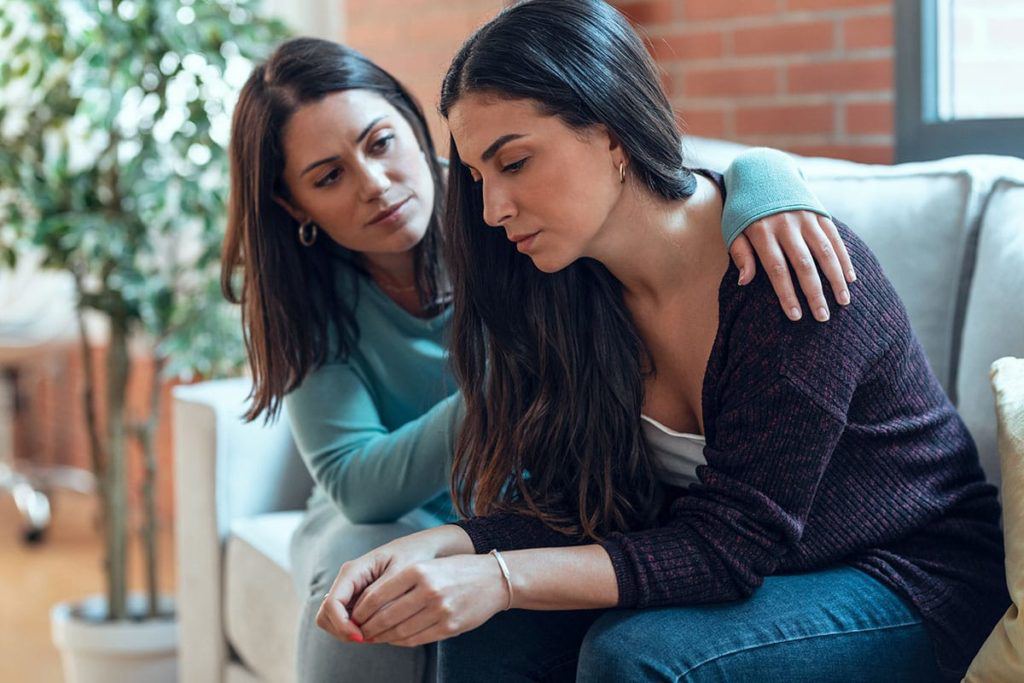 A woman consoling another woman