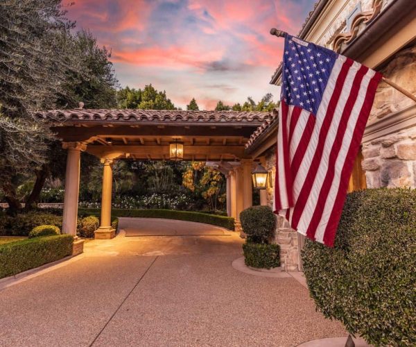 Outdoor setting at a California rehab center with tall trees an American flag